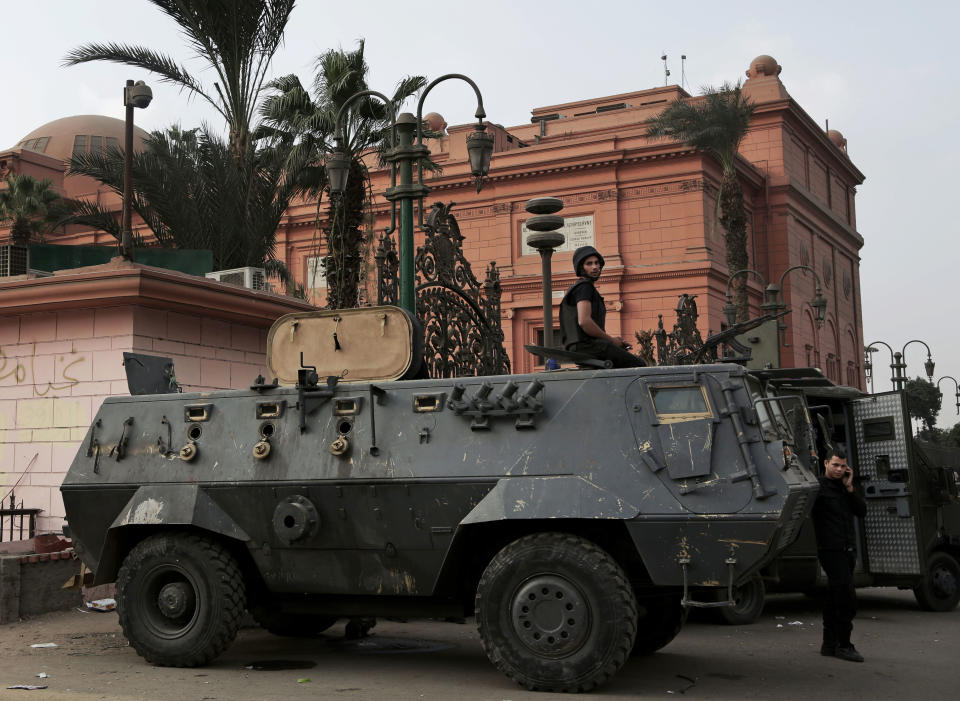 In this Wednesday, Oct. 30, 2013 photo, Egyptian security forces stand guard in front of the Egyptian museum near Tahrir Square in Cairo, Egypt. The 111-year-old museum, a treasure trove of pharaonic antiquities, has long been one of the centerpieces of tourism to Egypt. But the constant instability since the 2011 uprising that toppled autocrat Hosni Mubarak has dried up tourism to the country, slashing a key source of revenue. Moreover, political backbiting and attempts to stop corruption have had a knock-on effect of bringing a de facto ban on sending antiquities on tours to museums abroad, cutting off what was once a major source of funding for the museum.(AP Photo/Nariman El-Mofty)