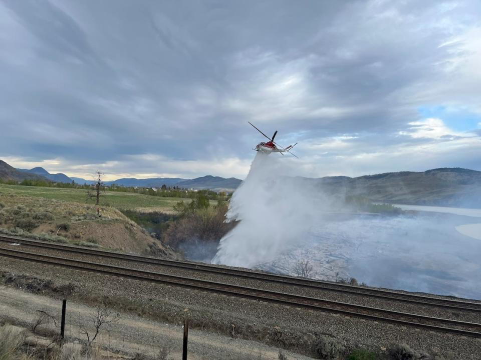 A B.C. Wildfire Service helicopter is seen at the scene of a grass fire in Kamloops, B.C., on Saturday, April 20, 2024.