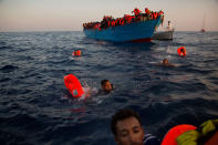 <p>Migrants, most of them from Eritrea, jumps into the water from a crowded wooden boat as they are helped by members of an NGO during a rescue operation at the Mediterranean sea, about 13 miles north of Sabratha, Libya, Monday, Aug. 29, 2016. (Photo: Emilio Morenatti/AP) </p>