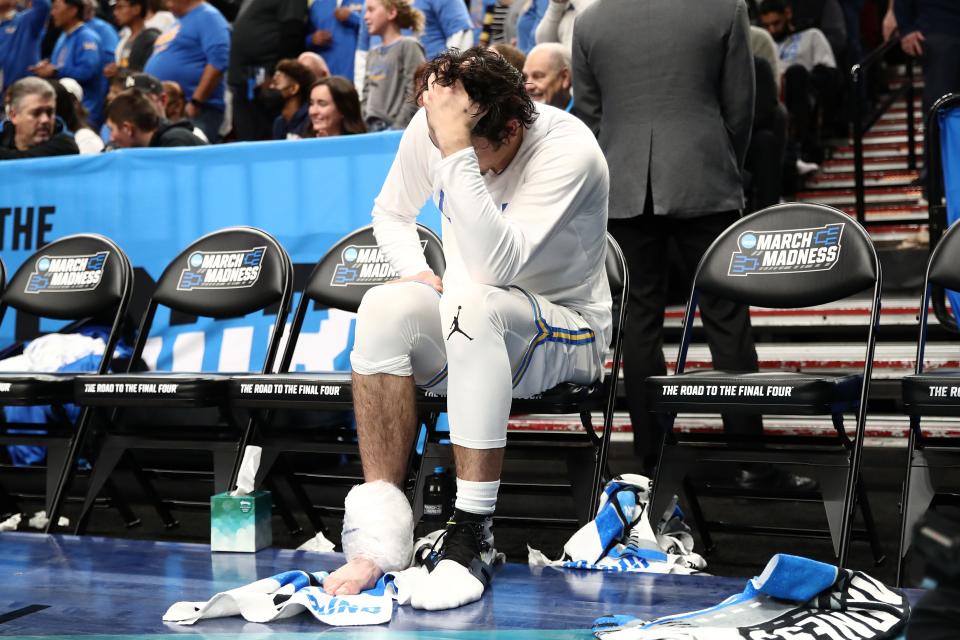 Jaime Jaquez Jr. of the UCLA Bruins reacts as he sits on the bench after injuring his right ankle against the Saint Mary's Gaels in the second round of the NCAA Tournament.