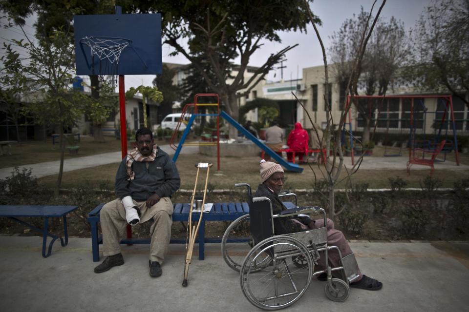 In this Saturday, Feb. 15, 2014, photo, Pakistani patients and residents at St. Joseph’s Hospice, Ashiq Kaka, 53, center, and William, 55, both suffered a stroke, sit in the garden part of their daily routine at the hospice, in Rawalpindi, Pakistan. Mohammed Aqeel spent weeks at home in Pakistan waiting for death after suffering a debilitating spinal cord injury in a car crash before friends suggested he come to St. Joseph’s Hospice on the outskirts of the capital, Islamabad. Now 13 years later, his life and those of some 40 others who live on its grounds might be changed forever as this hospital of last resort faces closure over its rising debts. (AP Photo/Muhammed Muheisen)