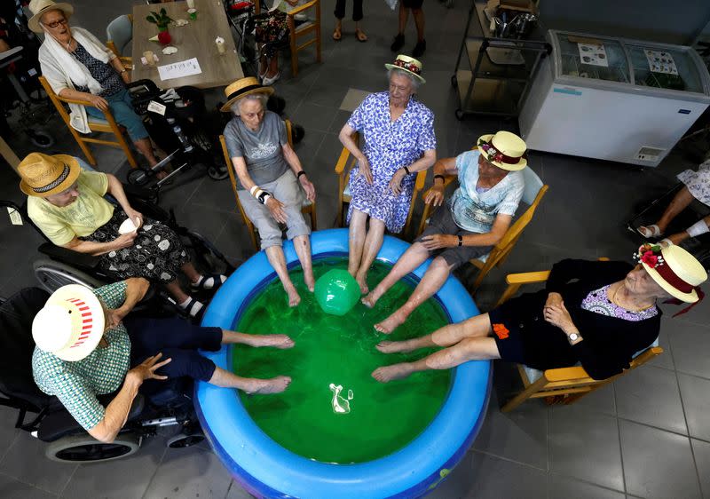 Residents at the Ter Biest house for elderly persons dip their feet in a pool as a heat wave hits Europe, in Grimbergen