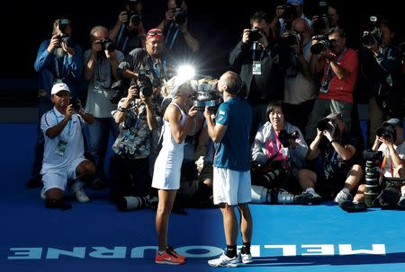 Russia's Elena Vesnina and Brazil's Bruno Soares kiss the mixed doubles trophy after winning their mixed doubles final match at the Australian Open tennis tournament at Melbourne Park, Australia, January 31, 2016. REUTERS/Tyrone Siu