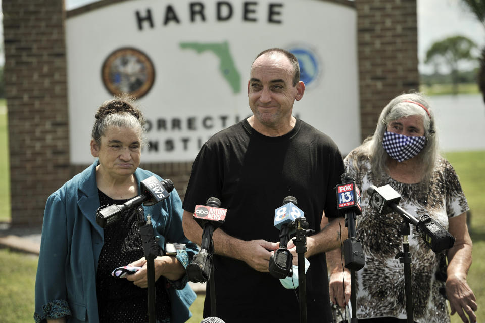 FILE - In this Aug. 27 2020 file photo, former inmate Robert DuBoise, 56, meets reporters with his sister Harriet, left, and mother Myra, right, following his release at the Hardee County Correctional Institute in Hardee County, Fla. DuBoise spent 37 years in a Florida prison for a 1983 rape and murder he did not commit. Now, he's set to receive $14 million from the city of Tampa as compensation for all those lost years. (AP Photo/Steve Nesius, File)