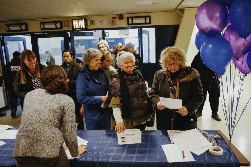 Supporters arrive at the Renaissance School for Musical Theater and Technology to attend the swearing-in ceremony and inaugural address of Rep. Alexandria Ocasio-Cortez in the Bronx borough of New York on Saturday, Feb. 16, 2019. (AP Photo/Kevin Hagen)