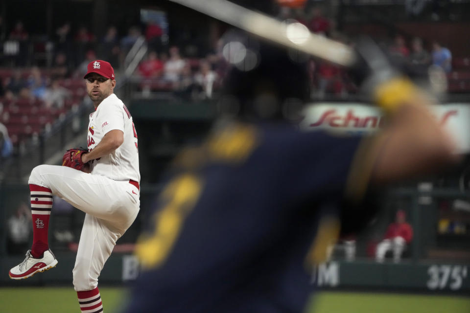 St. Louis Cardinals starting pitcher Adam Wainwright throws as Milwaukee Brewers' Josh Donaldson, right, warms up in the on-deck circle during the second inning of a baseball game Monday, Sept. 18, 2023, in St. Louis. (AP Photo/Jeff Roberson)