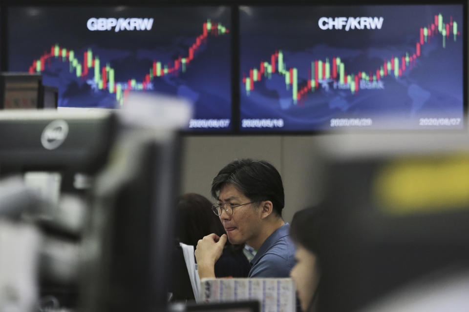 A currency trader watches monitors at the foreign exchange dealing room of the KEB Hana Bank headquarters in Seoul, South Korea, Friday, Aug. 7, 2020. Asian shares were mostly lower Friday in lackluster trading, as the region weighed continuing trade tensions over China and optimism about more fiscal stimulus for the ailing U.S. economy. (AP Photo/Ahn Young-joon)