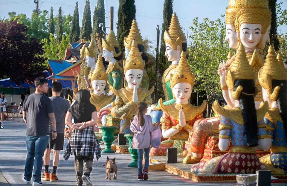 People look at some of the many statues depicting the life of the Buddha during the Cambodian New Year celebration at the Wat Dhammararam Buddhist temple in Stockton on Friday, Apr. 14, 2023. Thousands are expected to attend the 4-day cultural event which concludes on Sunday.