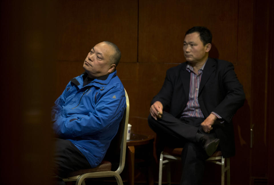 Chinese men watch TV after attending a briefing by Malaysia Airlines officials in a room reserved for relatives of passengers onboard the missing Malaysia Airlines flight MH370 at a hotel in Beijing, China Sunday, March 16, 2014. Attention focused Sunday on the pilots of the missing Malaysia Airlines flight after the country's leader announced findings so far that suggest someone with intimate knowledge of the Boeing 777's cockpit seized control of the plane and sent it off-course. (AP Photo/Andy Wong)