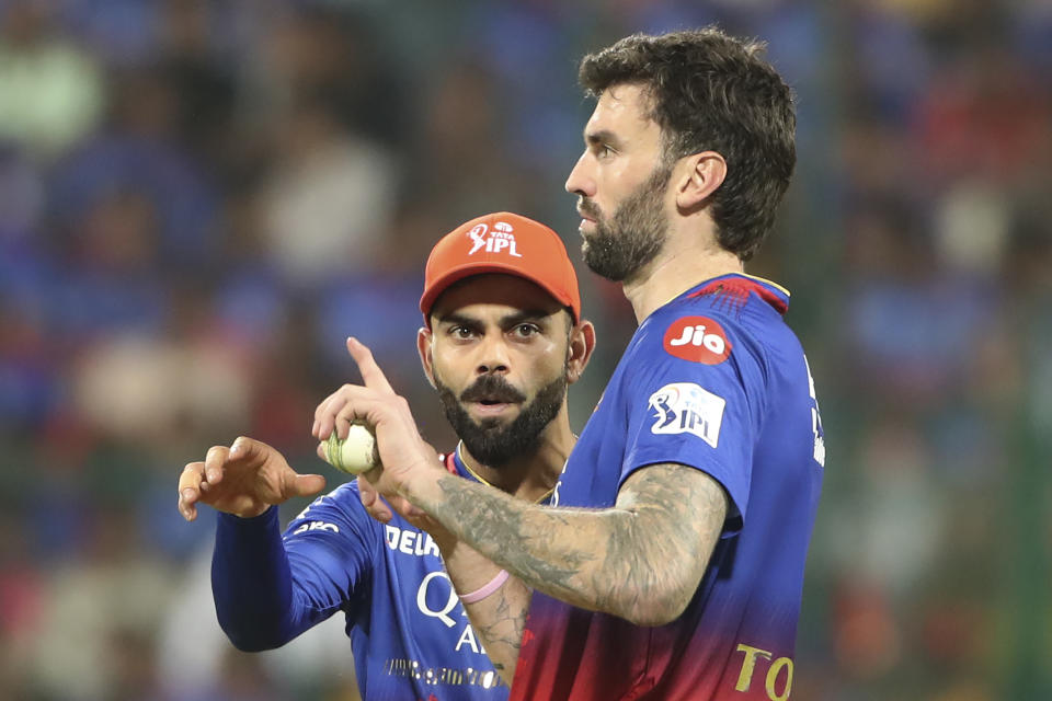 Royal Challengers Bengaluru's Virat Kohli speaks to bowler Reece Topley during the Indian Premier League cricket match between Royal Challengers Bangaluru and Sunrisers Hyderabad in Bengaluru, India, Monday, April 15, 2024. (AP Photo/Kashif Masood)