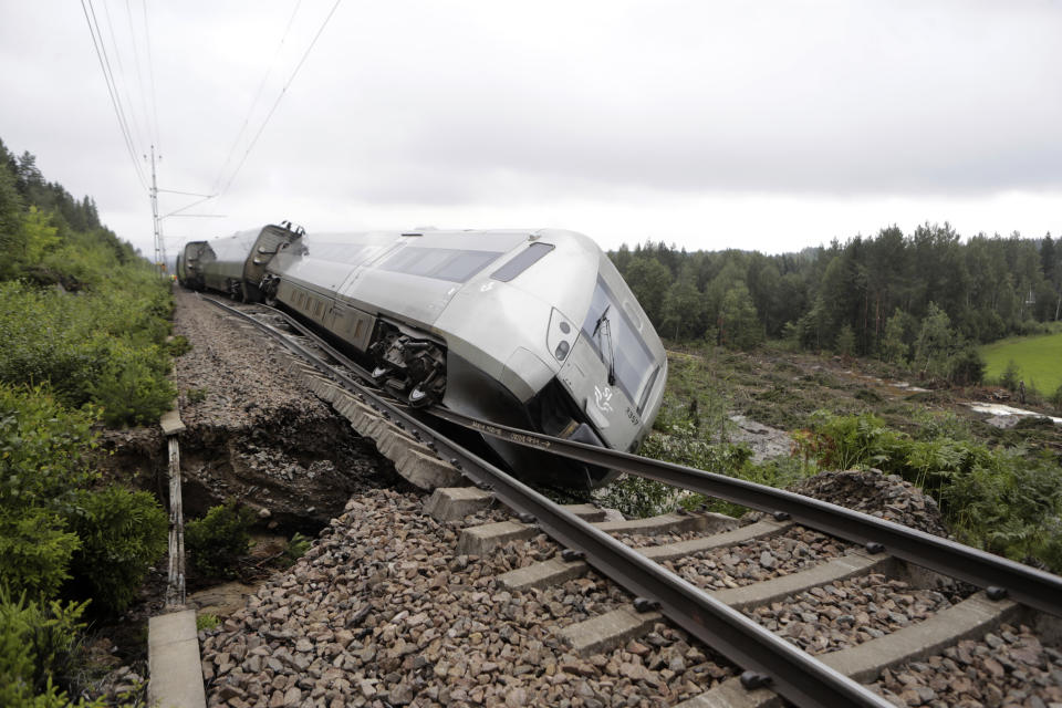 A passenger train carrying 120 passengers derailed between Iggesund and Hudiksvall in Sweden, Monday Aug. 7, 2023. Three people had been taken to hospital in Sweden when two of a train's passenger cars went off the tracks in Hudiksvall, north of Stockholm, police said. The derailment happened because ”the embankment has been undermined by the heavy rain and landslides,“ they said, adding that the extent of their injuries is unclear. (Mats Andersson/TT News Agency via AP)