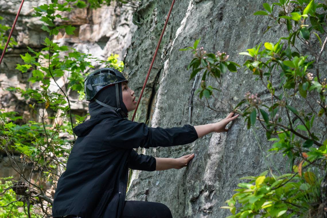 Sughra Yazdani, a 20-year-old Afghan woman living in Durham, sizes up the remainder of her climb up the ‘Fear of Flying’ area at Pilot Mountain State Park, north of Winston-Salem on Sunday, May 15, 2022.