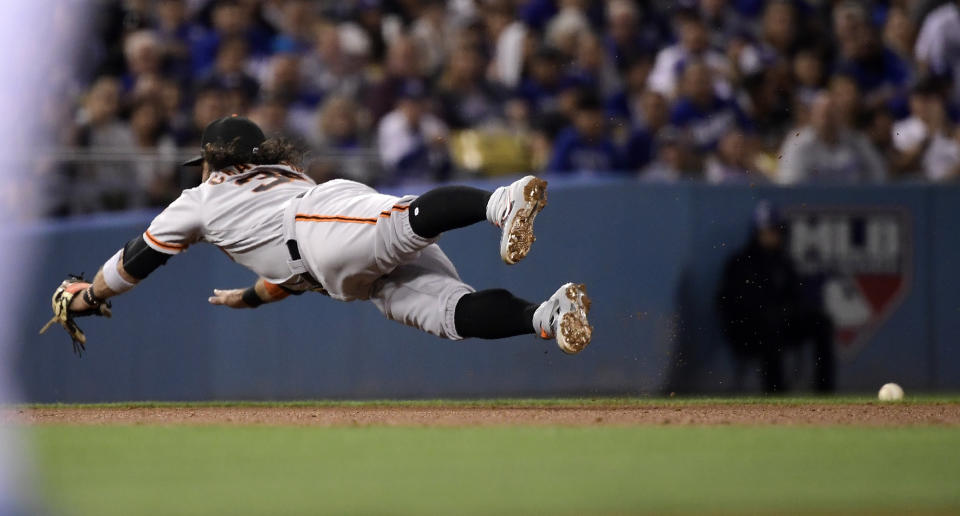 San Francisco Giants shortstop Brandon Crawford dives for but can't stop a ingle by Los Angeles Dodgers' David Freese during the fourth inning of a baseball game Thursday, June 20, 2019, in Los Angeles. (AP Photo/Mark J. Terrill)