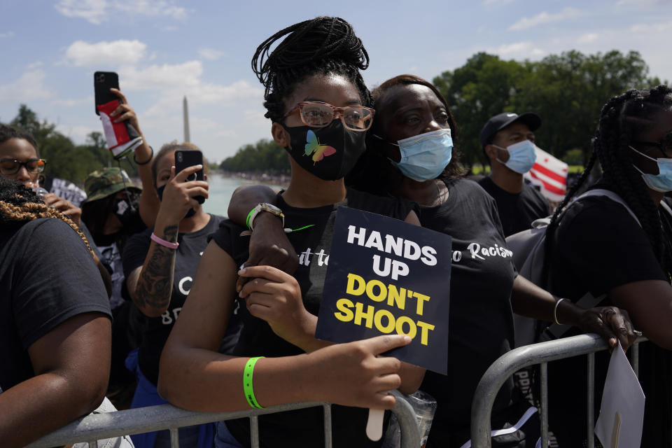 Audrey Dimartinez stands with her grand daughter Eliysia Leber as they listen to speakers during the March on Washington, Friday Aug. 28, 2020, in Washington, on the 57th anniversary of the Rev. Martin Luther King Jr.'s "I Have A Dream" speech. (AP Photo/Carolyn Kaster)