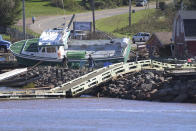 A lobster boat is seen grounded on the rocks at the wharf in Stanley Bridge, Prince Edward Island, Sunday Sept. 25, 2022. After hammering Atlantic Canada, post-tropical storm Fiona has moved inland in southeastern Quebec, with Environment Canada saying the storm will continue to weaken as it tracks across southeastern Labrador and over the Labrador Sea. (Brian McInnis/The Canadian Press via AP)