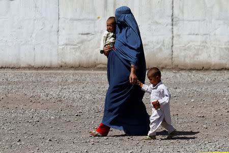 FILE PHOTO: An Afghan refugee woman arrives with her children to be repatriated to Afghanistan, at the United Nations High Commissioner for Refugees (UNHCR) office on the outskirts of Peshawar, Pakistan April 3, 2017. REUTERS/Fayaz Aziz/File Photo