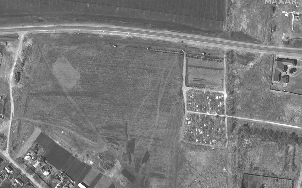This satellite image released by Maxar Technologies on April 21, 2022, shows an overview of a cemetery and expansion of graves site on the northwestern edge of Manhush, Ukraine (located approximately 20km west of Mariupol) and adjacent to an existing village cemetery, on March 26, 2022.  - Maxar Tech via Getty Images