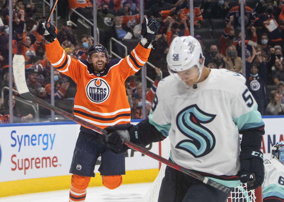 Edmonton Oilers' Brendan Perlini (42) celebrates a goal as Seattle Kraken's Connor Carrick (58) reacts during the second period of a preseason NHL hockey game in Edmonton, Alberta, Tuesday, Sept. 28, 2021. (Jason Franson/The Canadian Press via AP)