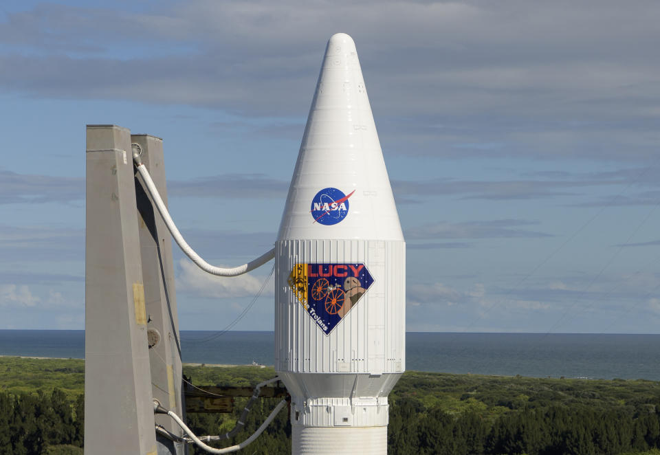 In this image released by NASA, a United Launch Alliance Atlas V rocket with the Lucy spacecraft aboard is rolled out of the Vertical Integration Facility to the launch pad at Space Launch Complex 41, Thursday, Oct. 14, 2021, in Cape Canaveral, Fla. The robotic trailblazer named Lucy is slated to blast off on Saturday on a 12-year cruise to unexplored swarms of asteroids out near Jupiter. (Bill Ingalls/NASA via AP)