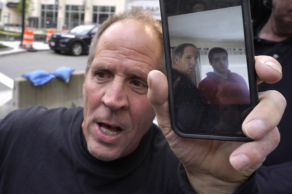 Paul Ventura, left, father of 18-year-old Mateo Ventura, both of Wakefield, Mass., displays a photograph on his cell phone that shows what he describes as a photo of himself, center left, and his son Mateo, right, while speaking with reporters outside federal court, Thursday, June 8, 2023, in Worcester, Mass. Mateo Ventura appeared in federal court, in Worcester, Thursday on a charge of knowingly concealing the source of material support or resources to a foreign terrorist organization, the U.S. attorney's office in Boston said in a statement. (AP Photo/Steven Senne)