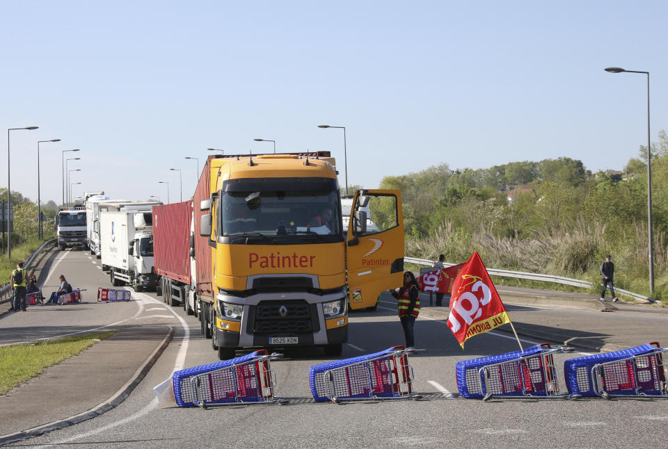 Demonstrators block the access to the Ikea store in protest against the pension reforms in Bayonne, southwestern France, Thursday, April 20, 2023. Union activists stage scattered actions to press France's government to scrap the new law raising the retirement age. (AP Photo/Bob Edme)