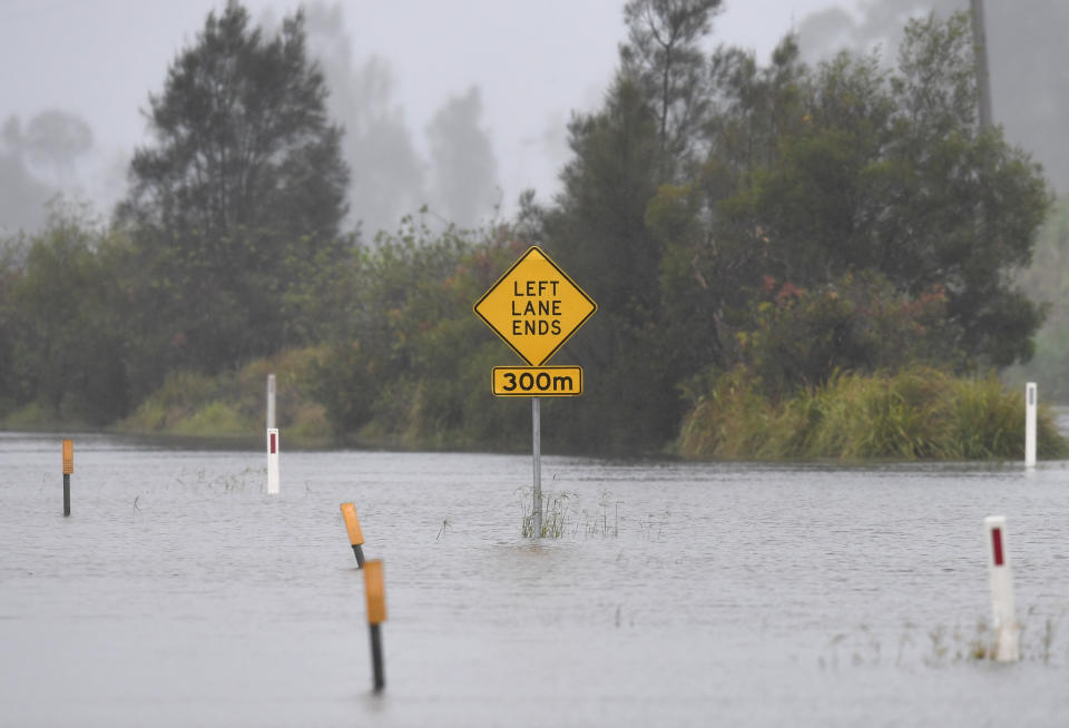 A road sign is surrounded by flood water at Tumbulgum, NSW on December 14. Source: AAP