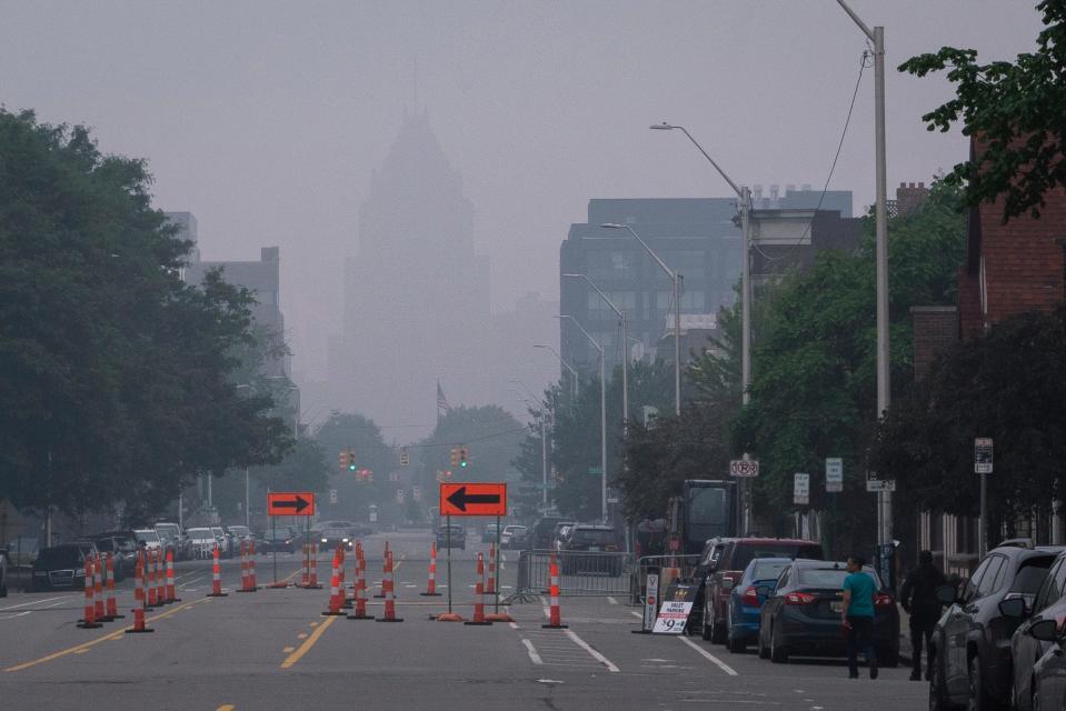 The Fisher Building is barely visible through haze and smoke, caused by the millions of acres burned by wildfires in Canada, in Midtown Detroit on Tuesday, June 27, 2023.