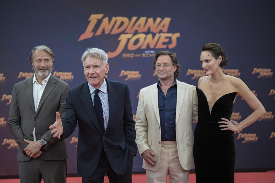 De izquierda a derecha, el actor danés Mads Mikkelsen, el actor estadounidense Harrison Ford, el actor alemán Thomas Kretschmann y la actriz británica Phoebe Waller-Bridge posan para fotógrafos en la alfombra roja de "Indiana Jones and the Dial of Destiny" en el cine Zoo Palast en Berlín, Alemania, el 22 de junio de 2023. (Hannes Albert/dpa vía AP)