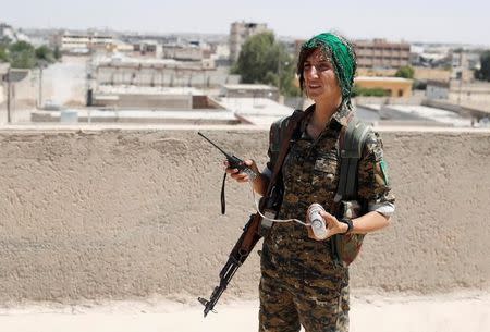 Sheen Ibrahim, Kurdish fighter from the People's Protection Units (YPG) stands on a roof top in Raqqa, Syria June 16, 2017. REUTERS/Goran Tomasevic