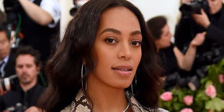 solange knowles on the 2019 met gala carpet in a snake print bazer with dark wavy hair