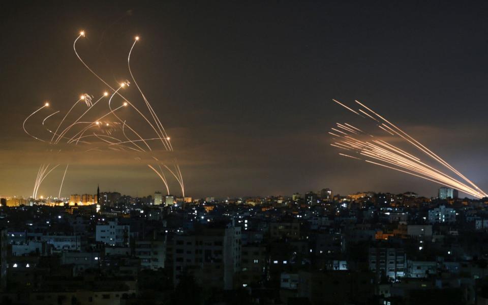 The Israeli Iron Dome missile defence system (L) intercepting rockets (R) fired by Hamas - ANAS BABA /AFP