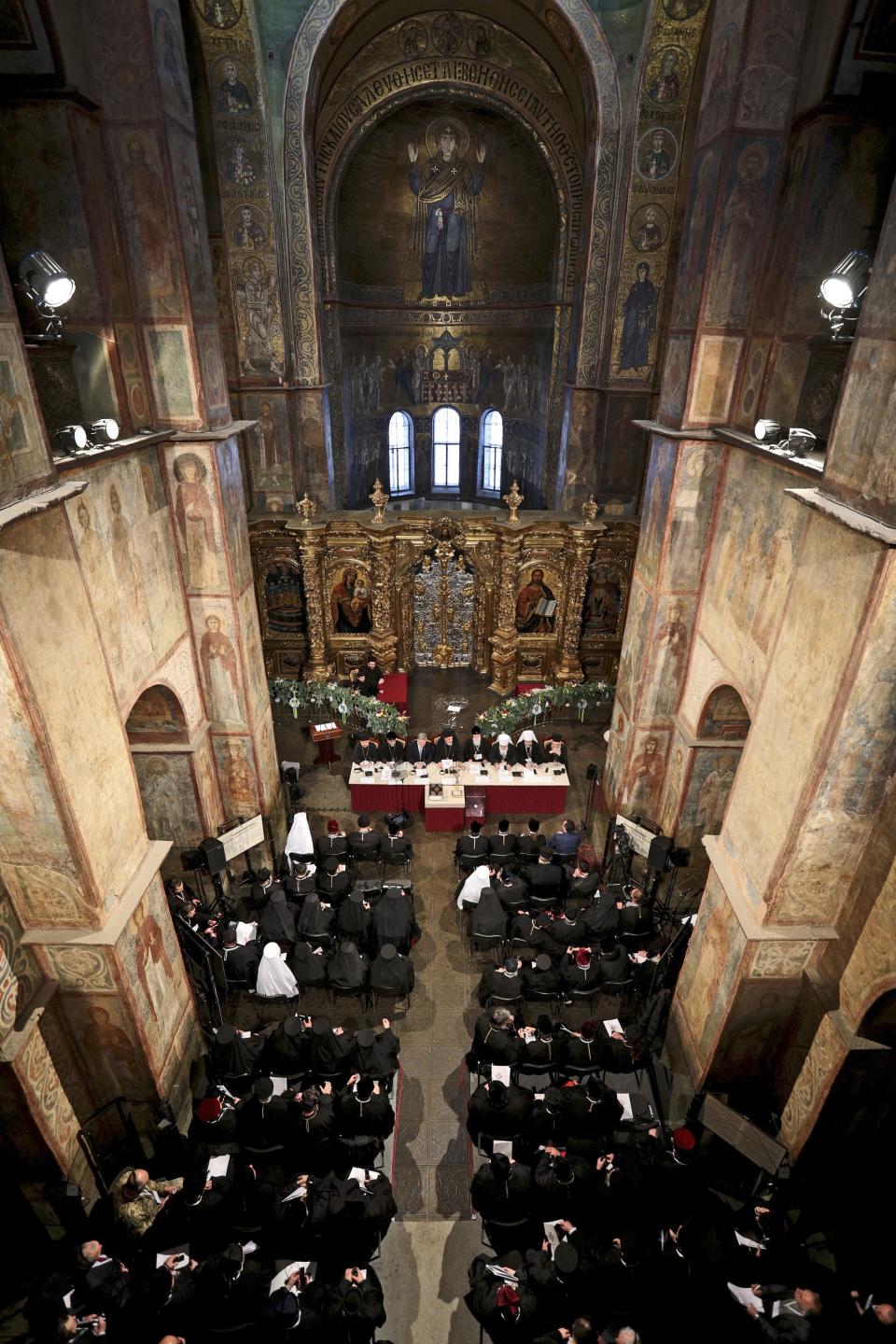 Ukrainian President Petro Poroshenko, backgrounder third left, attends a closed-door synod of three Ukrainian Orthodox churches to approve the charter for a unified church and to elect leadership in the St. Sophia Cathedral in Kiev, Ukraine, Saturday, Dec. 15, 2018. Poroshenko has told the crowd "the creation of our Church is another declaration of Ukraine's independence and you are the main participants of this historic event." (Mikhail Palinchak, Ukrainian Presidential Press Service/Pool Photo via AP)