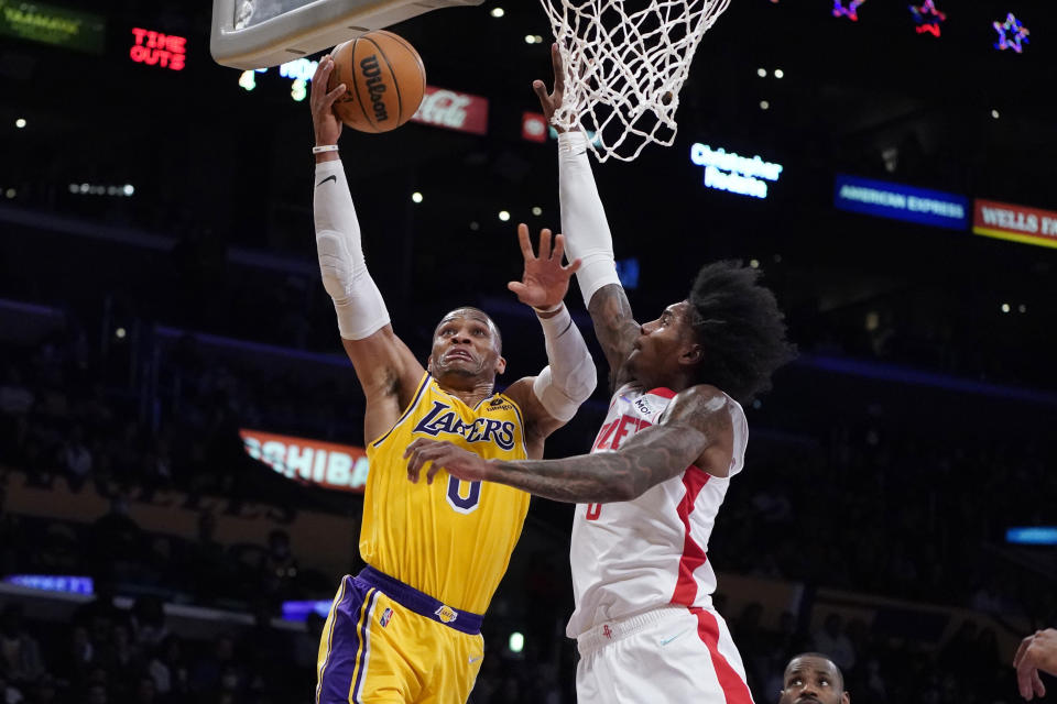 Los Angeles Lakers guard Russell Westbrook, left, drives to the basket as Houston Rockets guard Kevin Porter Jr. defends during the first half of an NBA basketball game Tuesday, Nov. 2, 2021, in Los Angeles. (AP Photo/Marcio Jose Sanchez)