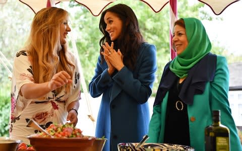 The Duchess of Sussex talks to women taking part in the project - Credit: BEN STANSALL /AFP