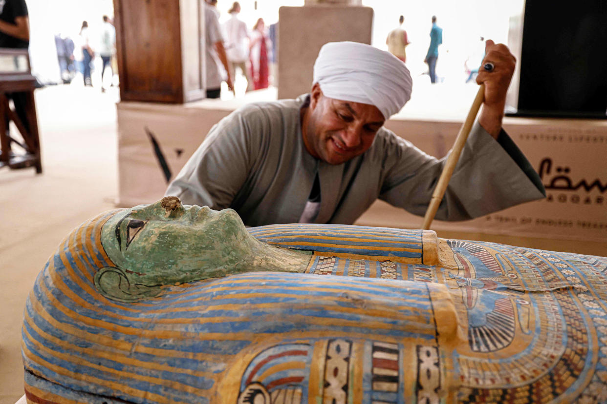 Mostafa Abdo Sadek observes a newly discovered sarcophagus in the Saqqara necropolis in Egypt, (Khaled Desouki / AFP via Getty Images)
