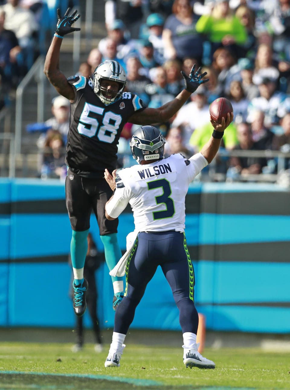 Carolina Panthers' Thomas Davis (58) jumps high as Seattle Seahawks' Russell Wilson (3) tries to pass during the first half of an NFL football game in Charlotte, N.C., Sunday, Nov. 25, 2018. (AP Photo/Jason E. Miczek)