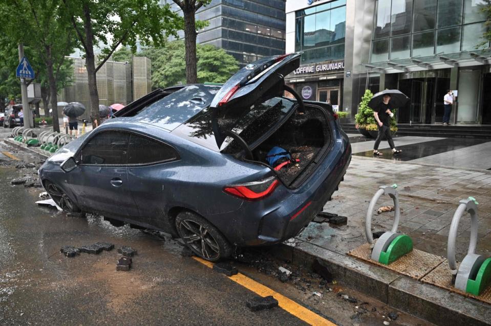 A car damaged by flood water is seen on the street after heavy rainfall at Gangnam district (AFP via Getty)