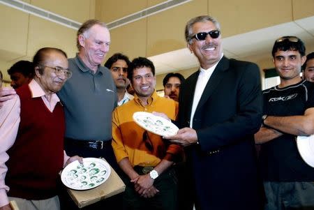 Former Pakistani cricketer Zaheer Abbas (2nd R) displays a plate carrying portraits of Pakistan's twelve great cricketers as Saurav Ganguly (R), Sachin Tendulkar (C), former Pakistani cricketer Hanif Mohammad (L) and Greg Chappell (2nd L) look on during a function after a lunch hosted for cricket players at a golf course in Karachi January 27, 2006. REUTERS/Arko Datta/Files