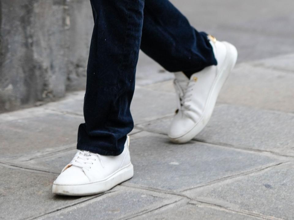 A man wearing plain white shoes.