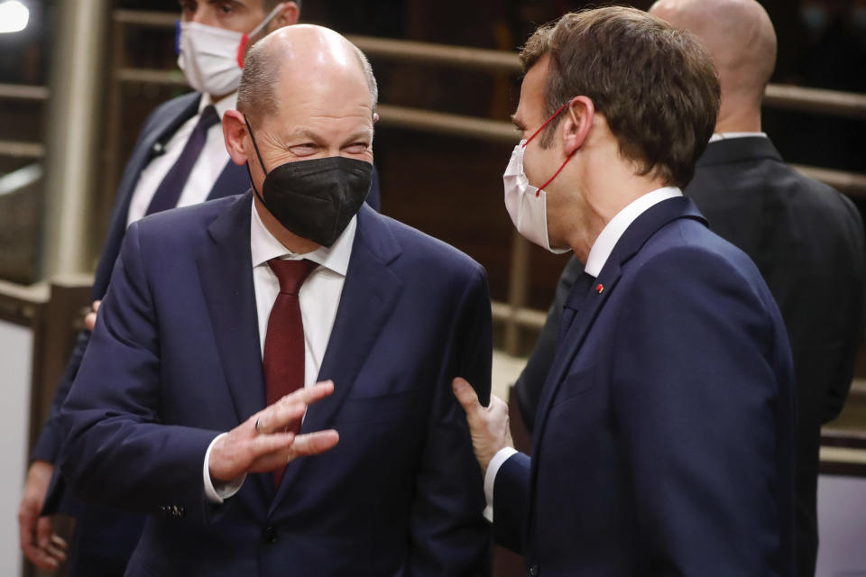German Chancellor Olaf Scholz, left, and French President Emmanuel Macron speak with each other during departures at the end of an EU Summit in Brussels, Friday, Dec. 17, 2021. European Union leaders met for a one-day summit Thursday focusing on Russia's military threat to neighbouring Ukraine and on ways to deal with the continuing COVID-19 crisis. (Stephanie Lecocq, Pool Photo via AP)