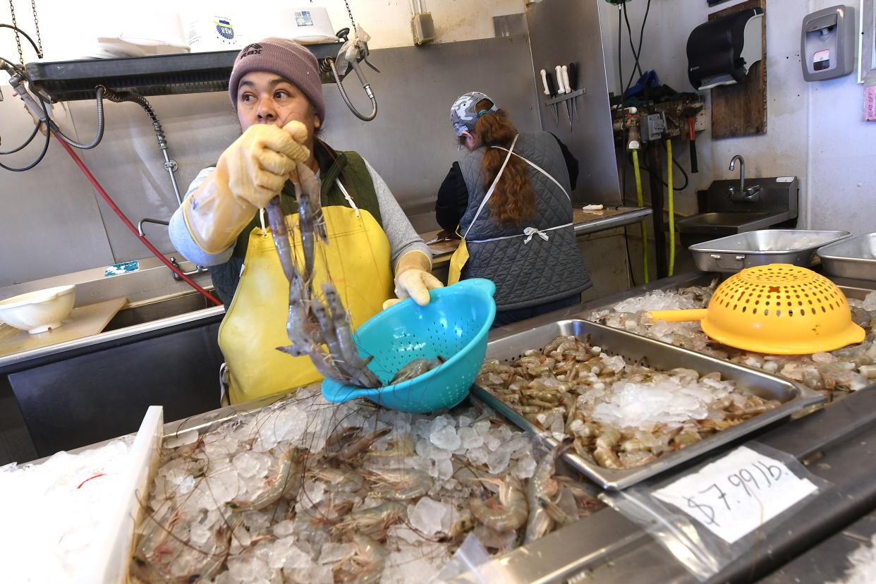 Workers fill seafood orders Friday Dec. 15, 2023 at Eagle Island Fruit and Seafood fish market in Wilmington, N.C. If you're looking to try your hand at preparing fresh seafood, the folks at our local seafood markets can help.