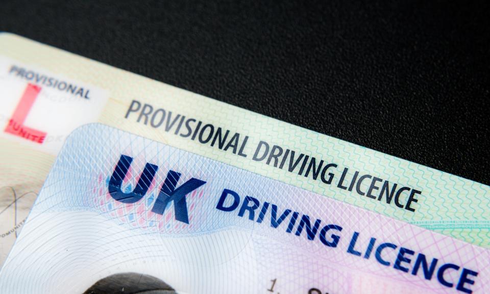 UK Driving Licence. Provisional and Full licence cards isolated on dark background. Macro. Selective focus. Stafford, United Kingdom, January 30, 2022
