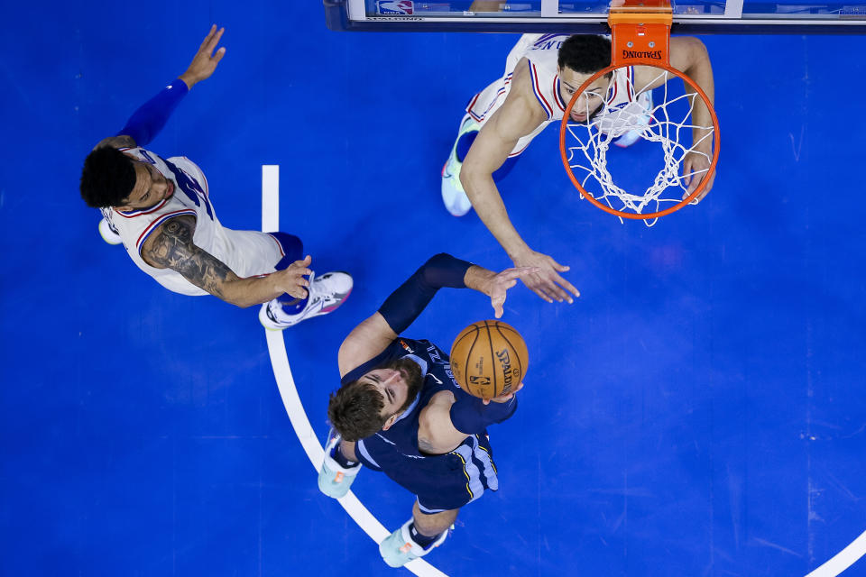 Memphis Grizzlies' Jonas Valanciunas, center, shoots the ball with Philadelphia 76ers' Ben Simmons, right, and Danny Green, left, defending during the first half of an NBA basketball game, Sunday, April 4, 2021, in Philadelphia. (AP Photo/Chris Szagola)