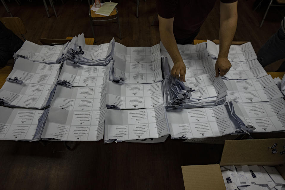 Electoral workers count ballots after the polls closed during an election to choose members of a Constitutional Council who will draft a new constitution proposal in Santiago, Chile, Sunday, May 7, 2023. A first attempt to replace the current charter bequeathed by the military 42 years ago was rejected by voters during a referendum in 2022. (AP Photo/Esteban Felix)