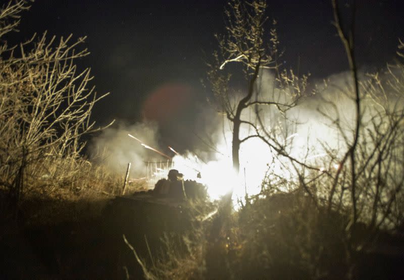 An armoured personnel carrier of Ukrainian armed forces fires a weapon from its position on the front line near the village of Krymske