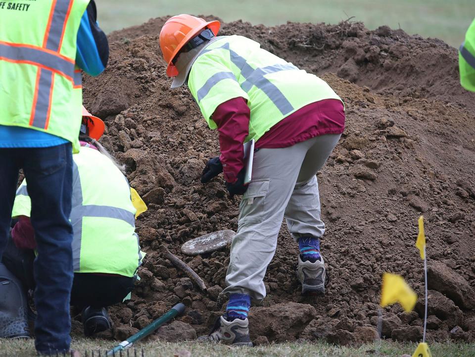 Researchers search through dirt and items dug out during a second test excavation and core sampling Tuesday, Oct. 20, 2020, in the search for remains at Oaklawn Cemetery in Tulsa, Okla., from the 1921 Tulsa race massacre.