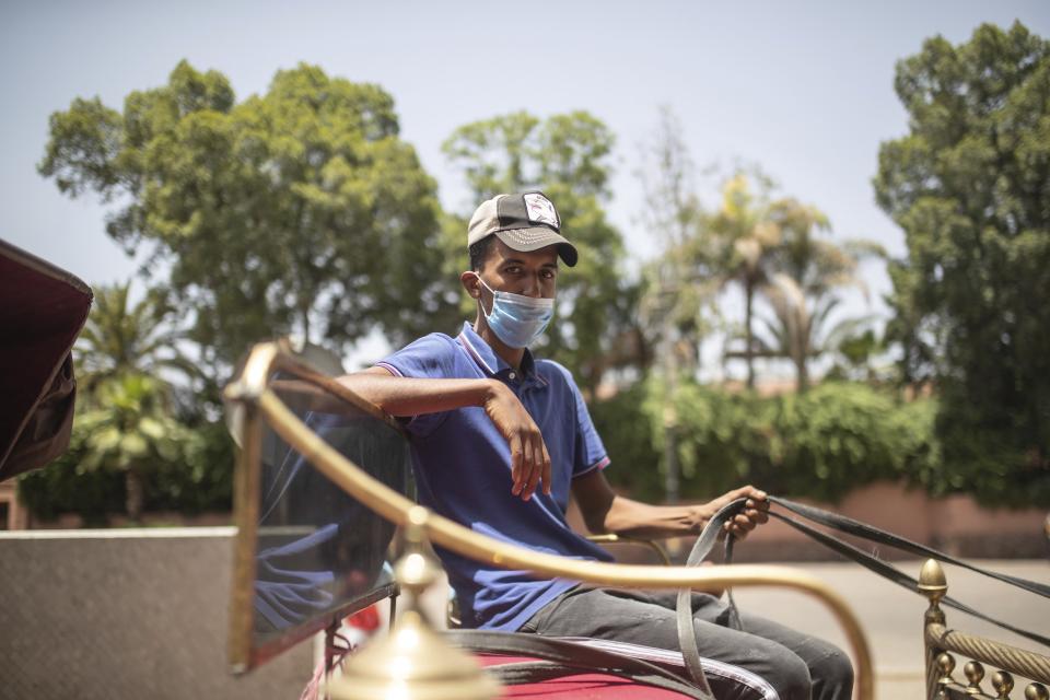 Sabeh Boualili, a horse carriage owner, waits for customers in the landmark Jemma el-Fnaa in Marrakech, Morocco, Wednesday, July 22, 2020. (AP Photo/Mosa'ab Elshamy)