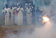 Villagers burst firecrackers and hold placards featuring U.S. Vice President-elect Kamala Harris ahead of her inauguration, in Thulasendrapuram, the hometown of Harris' maternal grandfather, south of Chennai, Tamil Nadu state, India, Wednesday, Jan. 20, 2021. A tiny, lush-green Indian village surrounded by rice paddy fields was beaming with joy Wednesday hours before its descendant, Kamala Harris, takes her oath of office and becomes the U.S. vice president. (AP Photo/Aijaz Rahi)