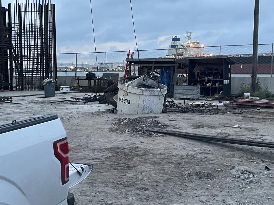 A concrete bucket that fell from a 450-foot tower crane sticks out of the ground at a Harbor Bridge construction site on April 22, 2023, in Corpus Christi, Texas. A baseball spectator at Whataburger Field was reportedly struck by flying debris and was hospitalized for three days.