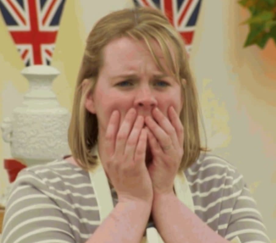 A "Great British Baking Show" contestant covers her face during a stressful moment